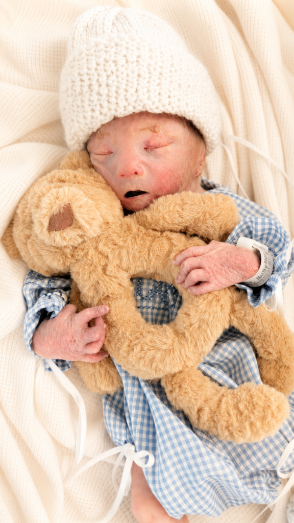 Theodore holding his teddy bear rattler